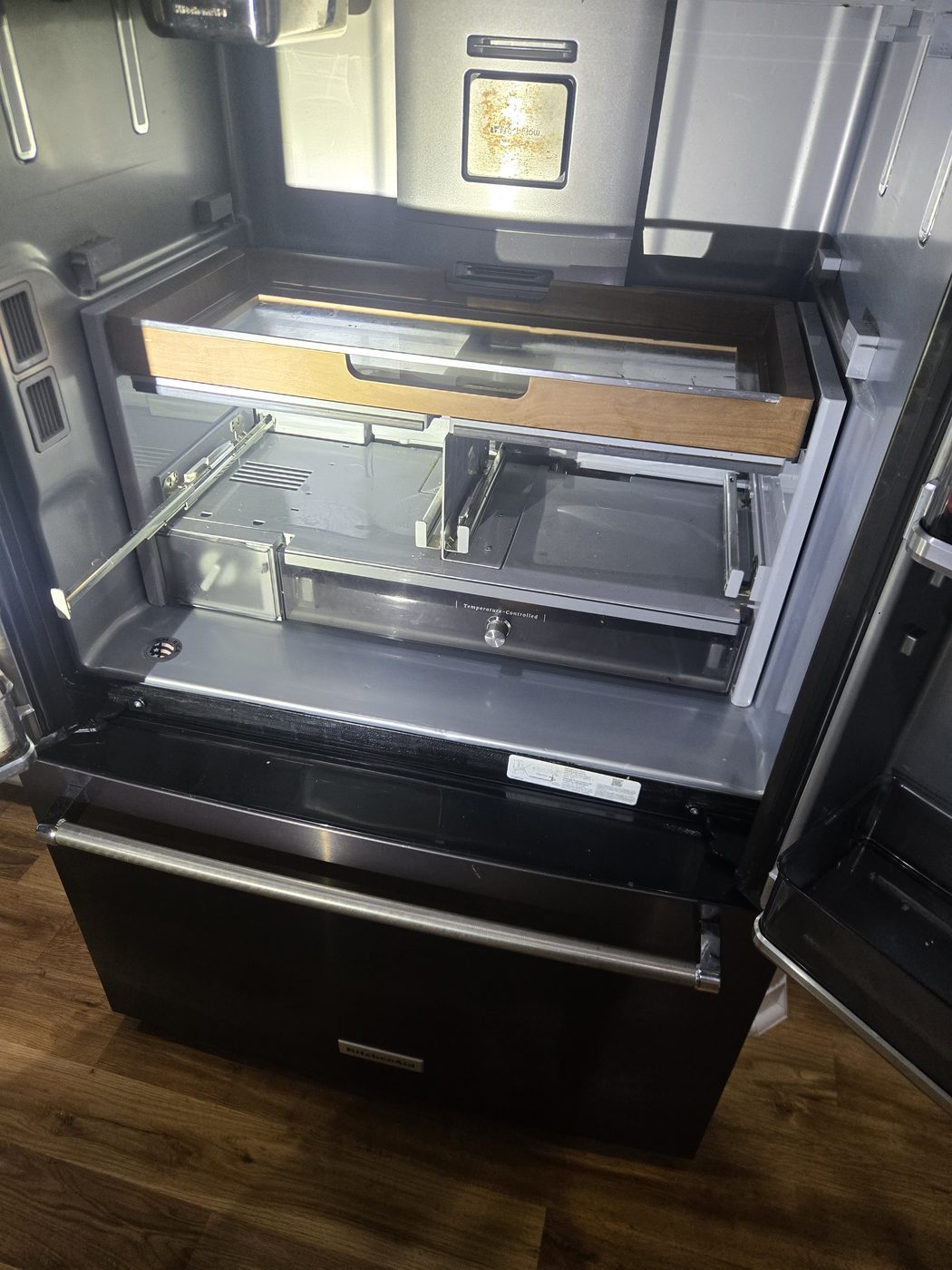 Black stainless French-door refrigerator with doors open