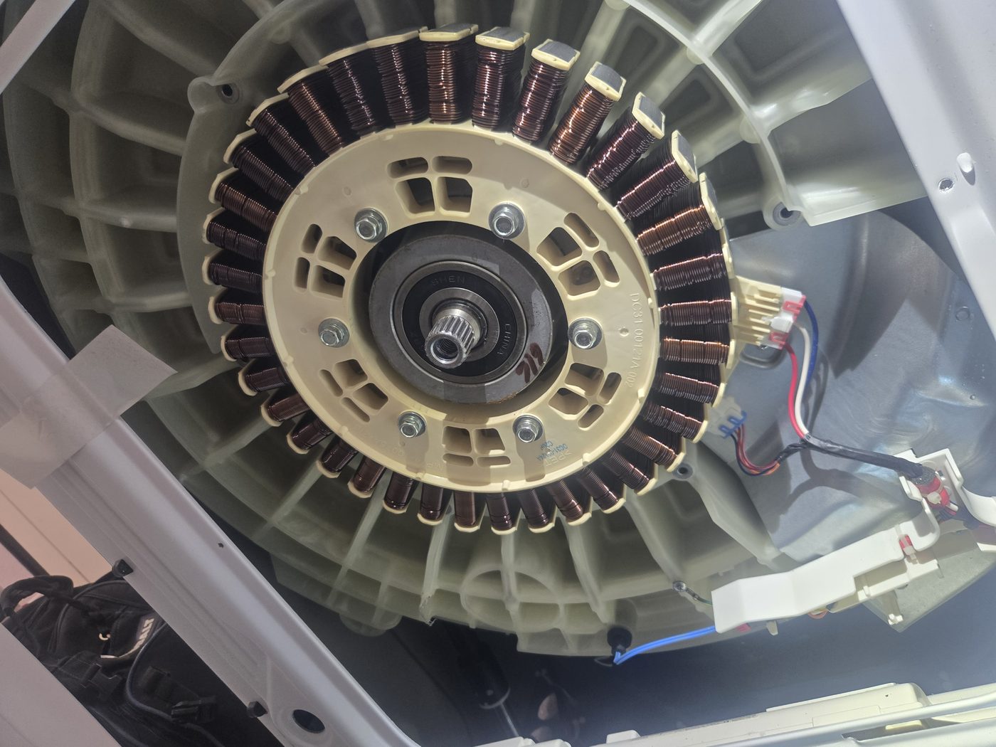 A washer motor and stator assembly exposed during a repair