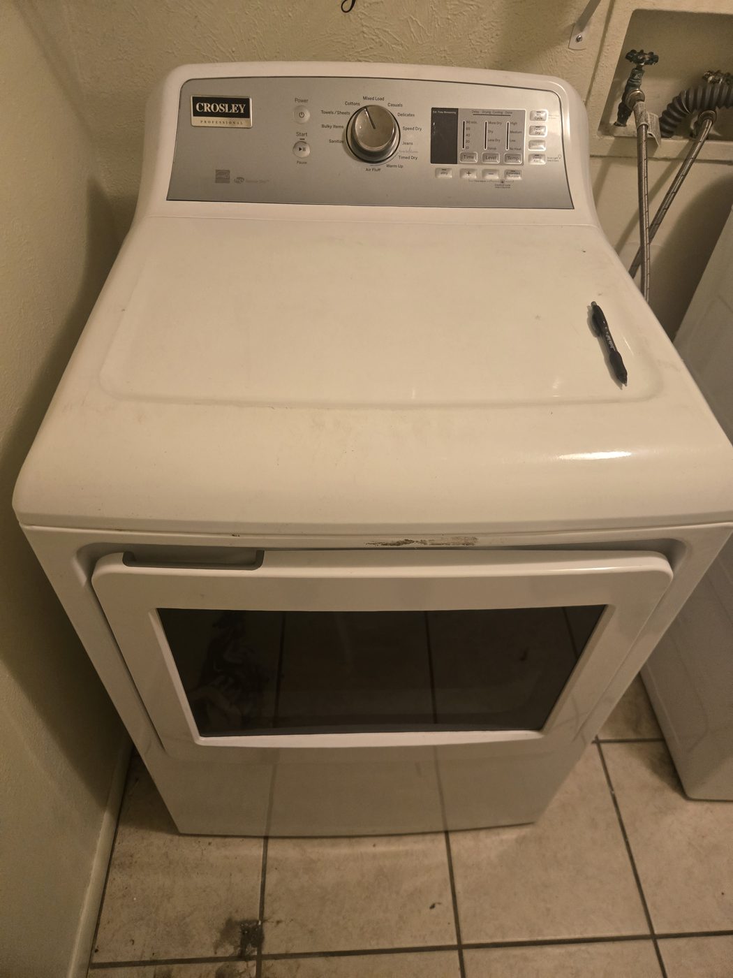 A clean white dryer in a home laundry room